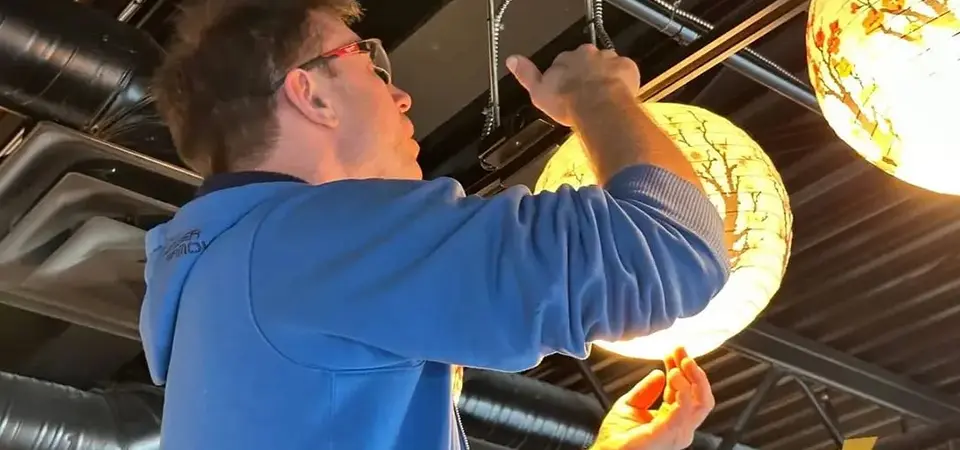 Man installing restaurant lighting fixtures.